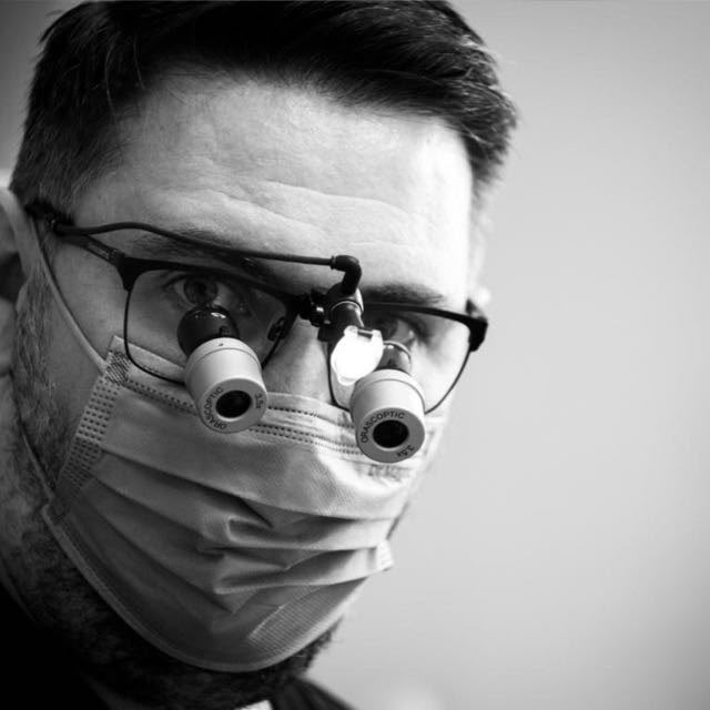 Dr. Alexandru Butnaru în timpul unui tratament, purtând lupe stomatologice
